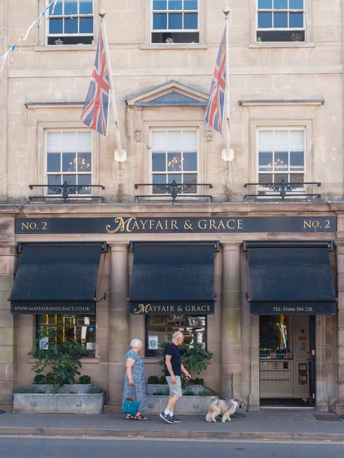 The image shows the exterior of a building with a stone facade housing 'Mayfair & Grace', a business that appears to be involved in relocations or removals, as indicated by the context of the webpage.