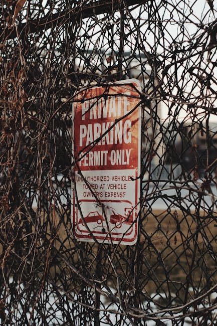 Four blue parking signs mounted on tall, black metal poles positioned against a corrugated silver metal wall. The signs display a white 'P' symbol, with the words 'vergunning-houders' and 'AUTODATE' w